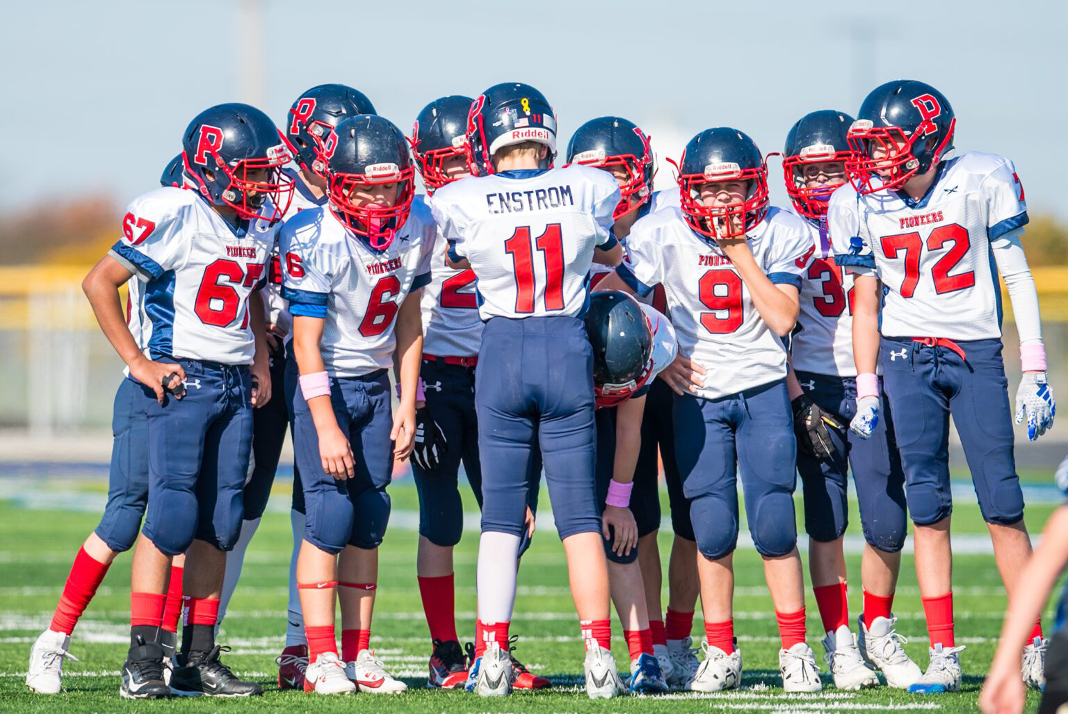 Orland Park Pioneers tackle football players in a huddle